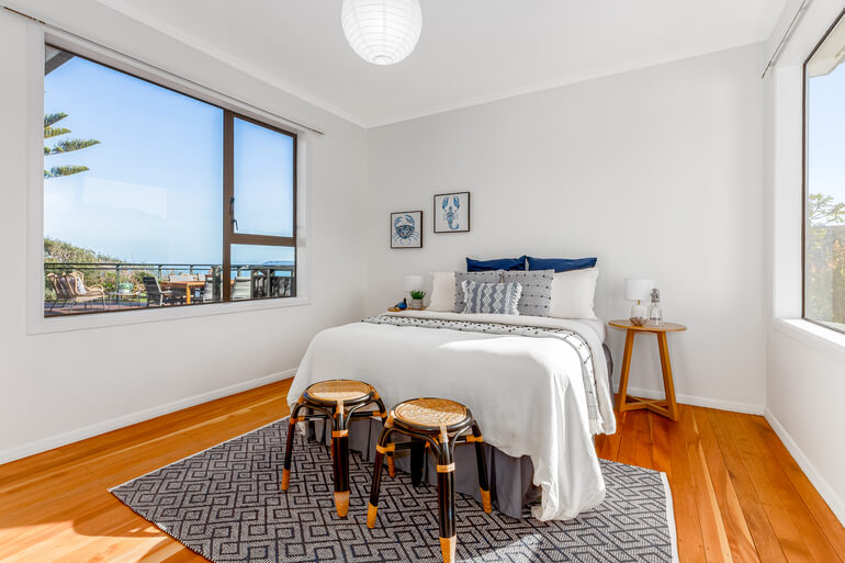 Before and after real estate photo editing of a bedroom with enhanced brightness, color, and detail.