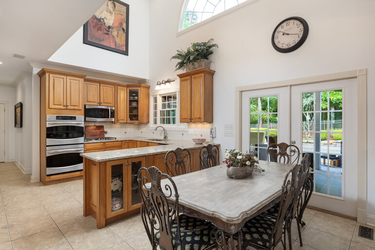 Before-and-after comparison of real estate HDR photo editing, showcasing bracketed exposure blending and window pulls in a kitchen.