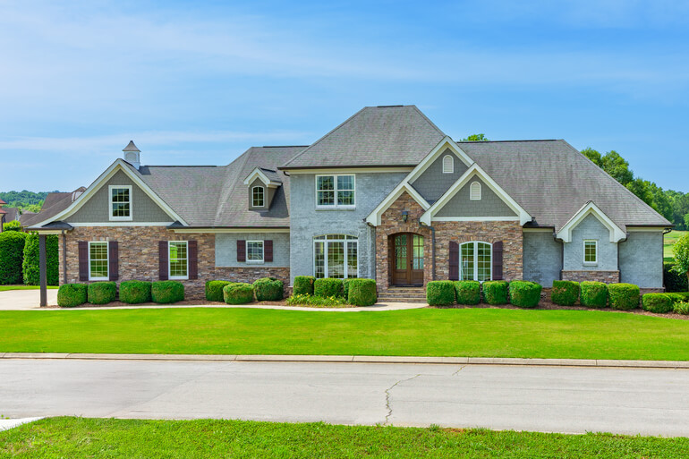 Side-by-side comparison of a home exterior illustrating advanced real estate photo editing, sky replacement, and object removal.
