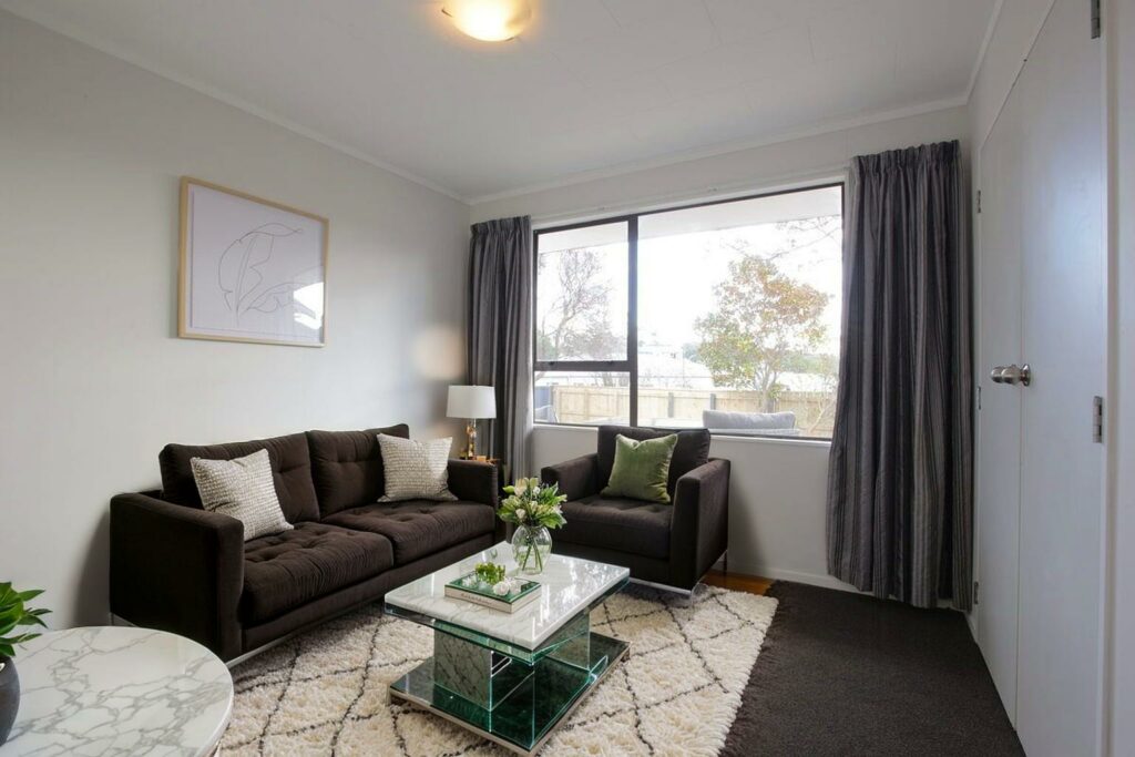 Virtually staged living room with dark furniture and modern accents.