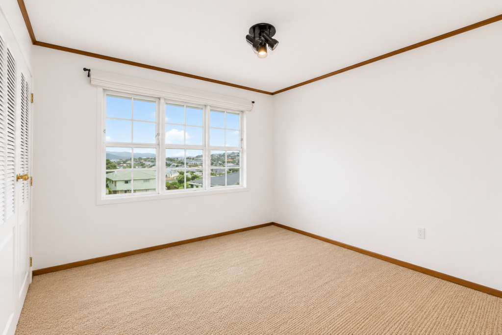 Empty dining room with white walls and a window.