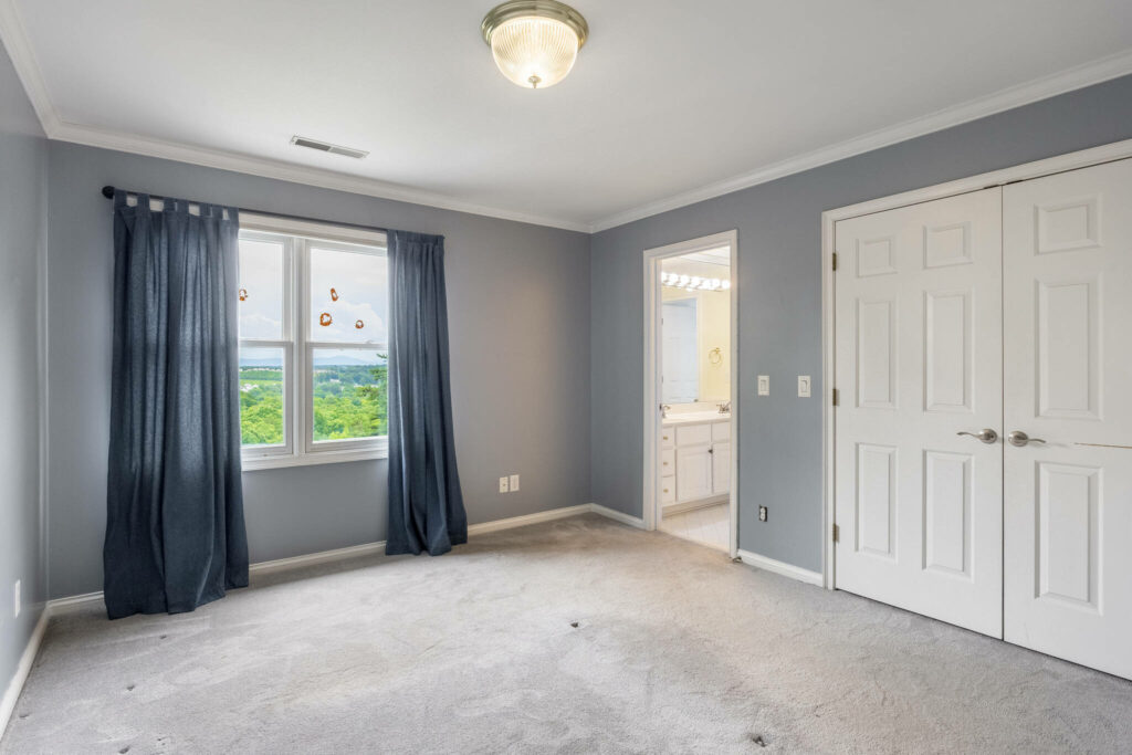 Empty bedroom before virtual staging with gray walls and natural light.