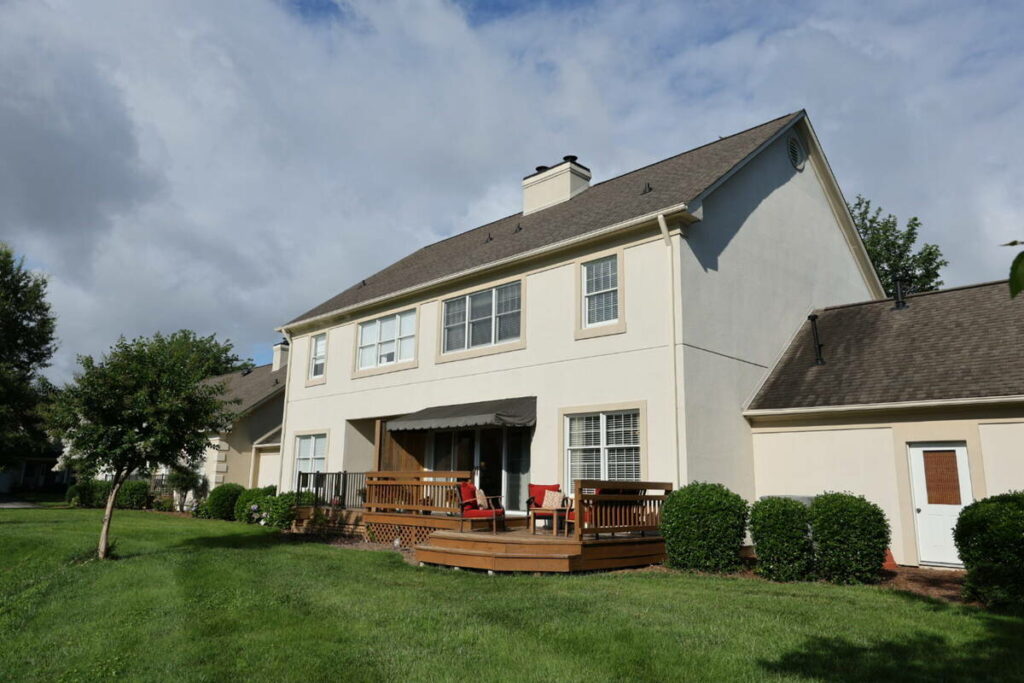 Unedited backyard exterior of a two-story home before photo editing outsourcing.