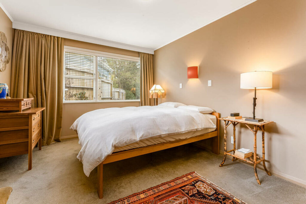 Cozy bedroom with large window and neutral decor.