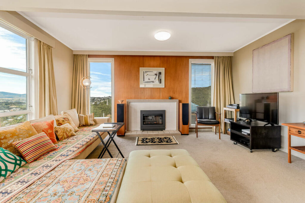 Bright living room with fireplace and panoramic windows.
