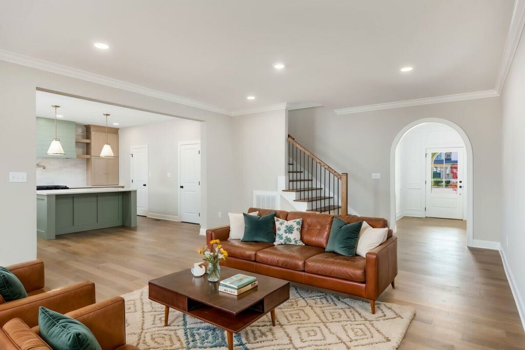 Virtually staged family room featuring brown leather furniture.
