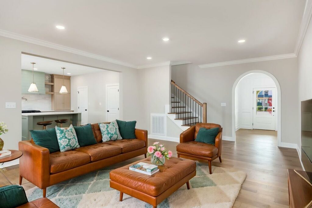 Virtually staged living room with green leather furniture and modern décor.