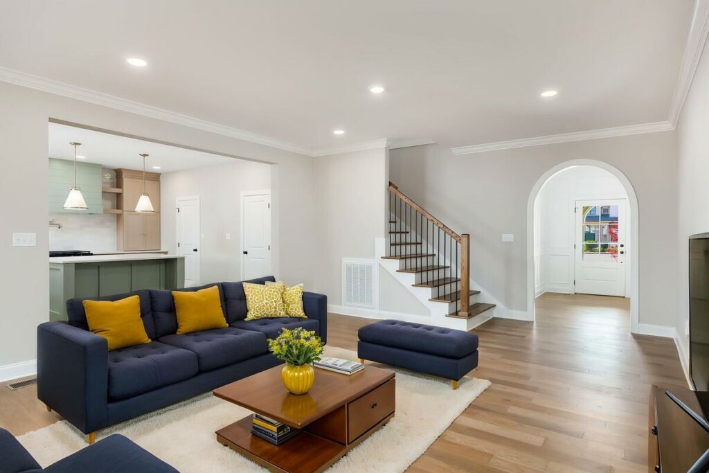 Modern living room with a navy blue sofa and yellow accent pillows.