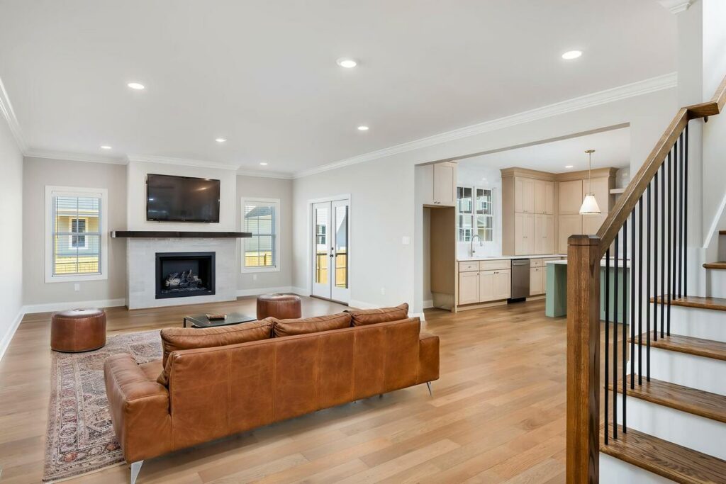 Spacious living room featuring tan leather furniture and warm finishes.