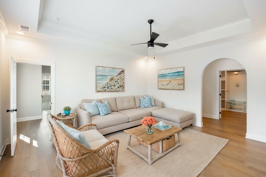 Coastal-inspired living room with a sectional sofa and beach artwork.