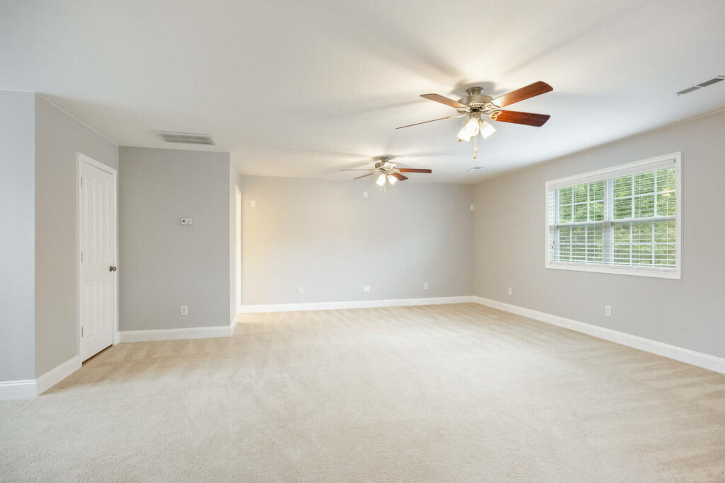 AI real estate photo editing of an empty bedroom with improved lighting and balanced exposure.