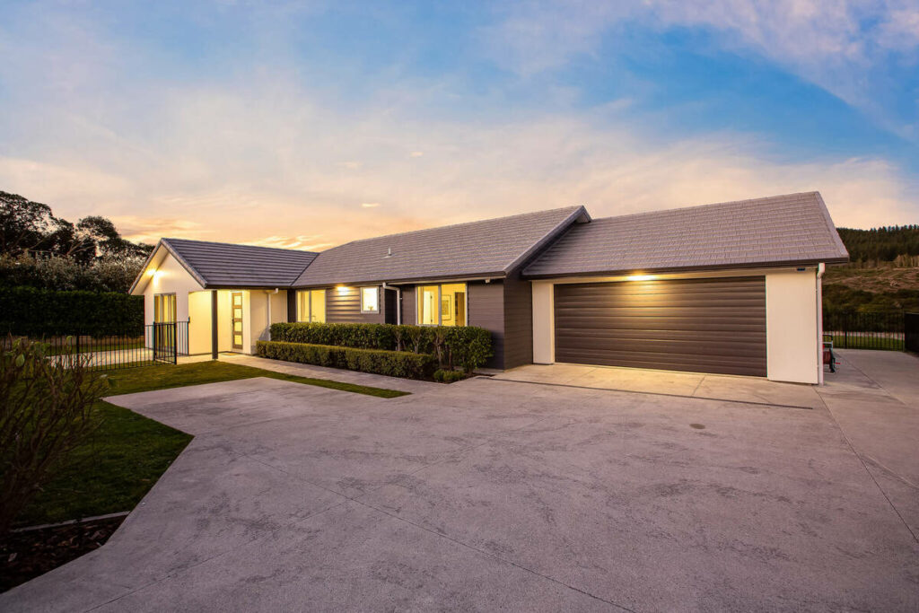AI real estate photo editing enhancing a modern home exterior with a sunset sky and warm lighting.