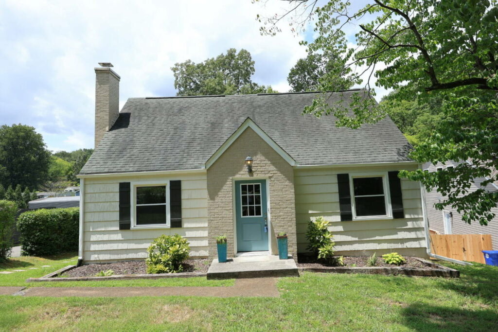 AI real estate photo editing example of a small home exterior before sky replacement and color enhancement.