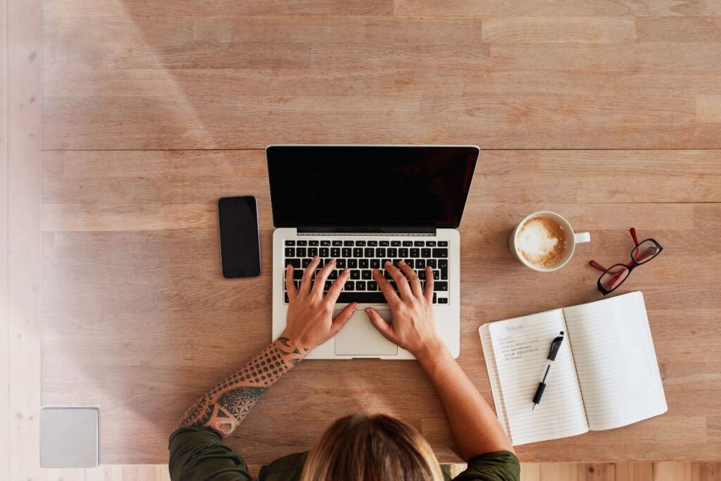 Photography coordinator managing tasks from a laptop