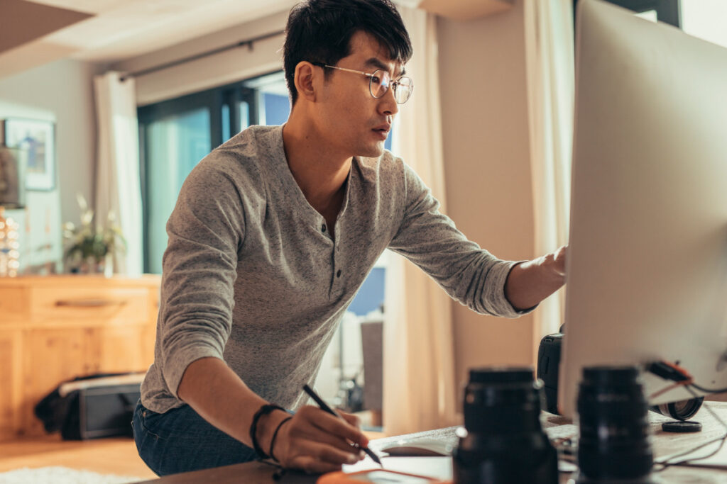 Photographer working at a computer to edit and manage client photos