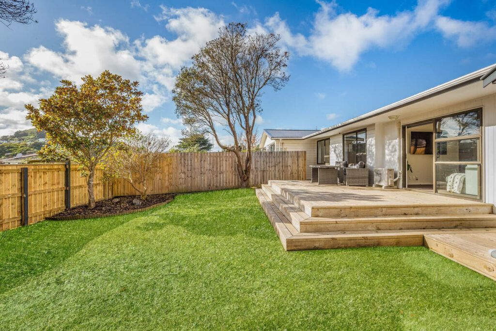 Backyard after AI real estate photo editing with enhanced grass and sky