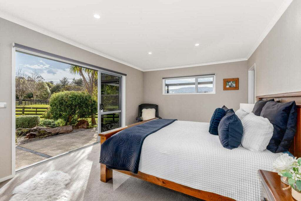 Bedroom after AI real estate photo editing with balanced window exposure