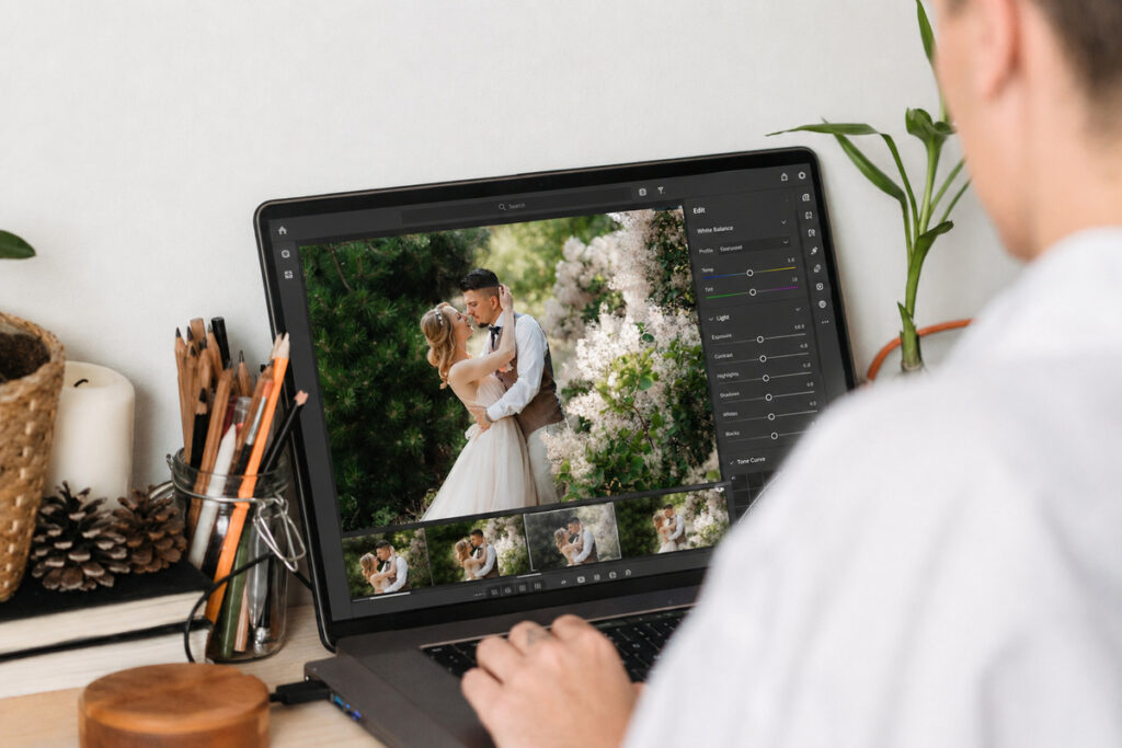 Editor performing wedding photo editing and color correction on a laptop
