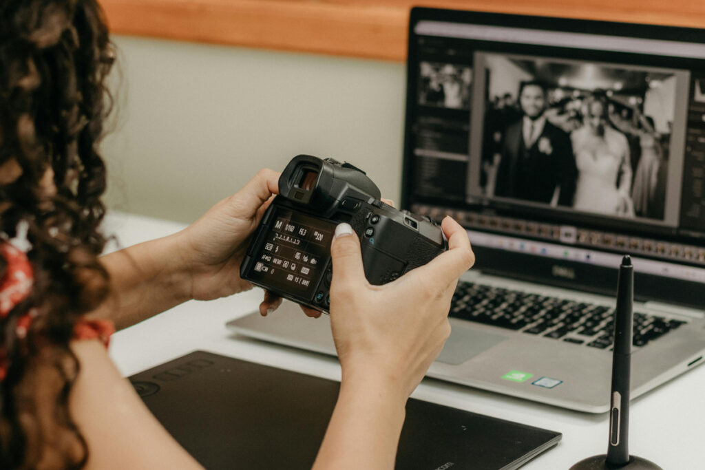 Wedding photo editing workflow with photographer reviewing images on a camera