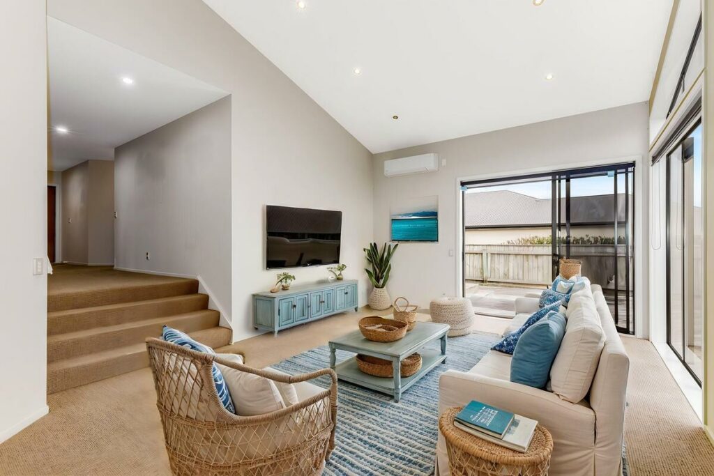 AI virtual staging of a bright coastal living room with blue accents