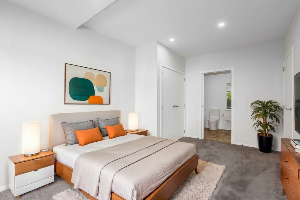 AI virtual staging of a bedroom with neutral tones and orange accents