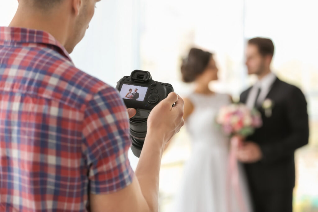 Wedding photographer capturing a couple before professional wedding photo editing services