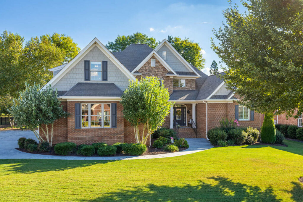 Architecture photography of a luxury brick home exterior with landscaped front yard.
