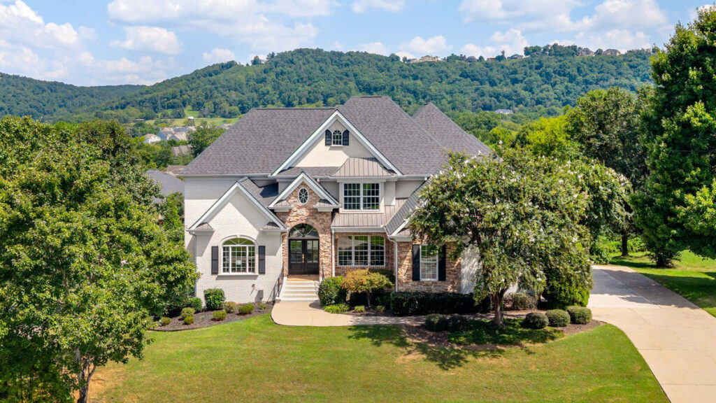 Architecture photography of a luxury home exterior surrounded by trees and rolling hills.