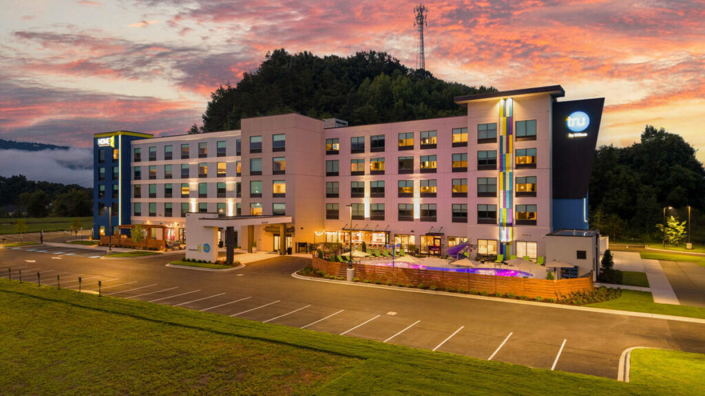 Architecture photography of a modern hotel exterior illuminated against a colorful twilight sky.