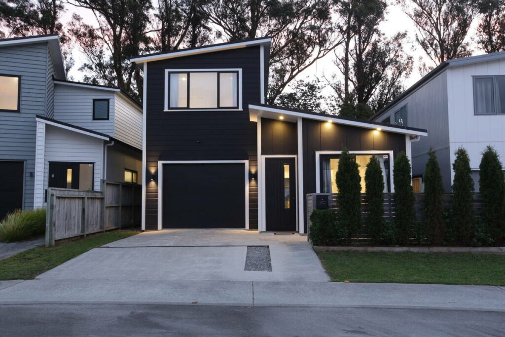 Architecture photography of a modern black and white home exterior at twilight.