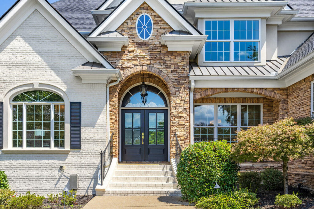 Architecture photography of a luxury home entrance with detailed stonework and balanced exposure.
