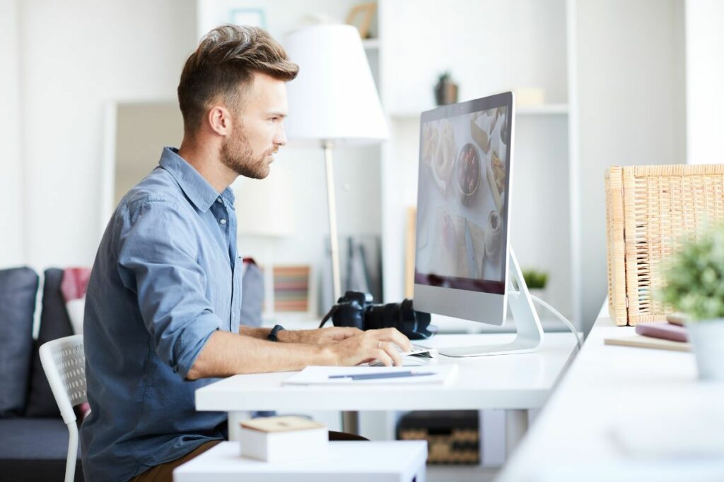 Commercial photographer working on post-production images at a desktop computer
