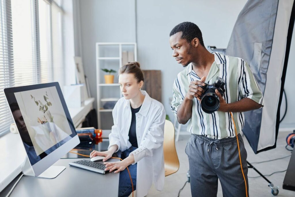 Commercial photographer reviewing images with an editor during a studio shoot