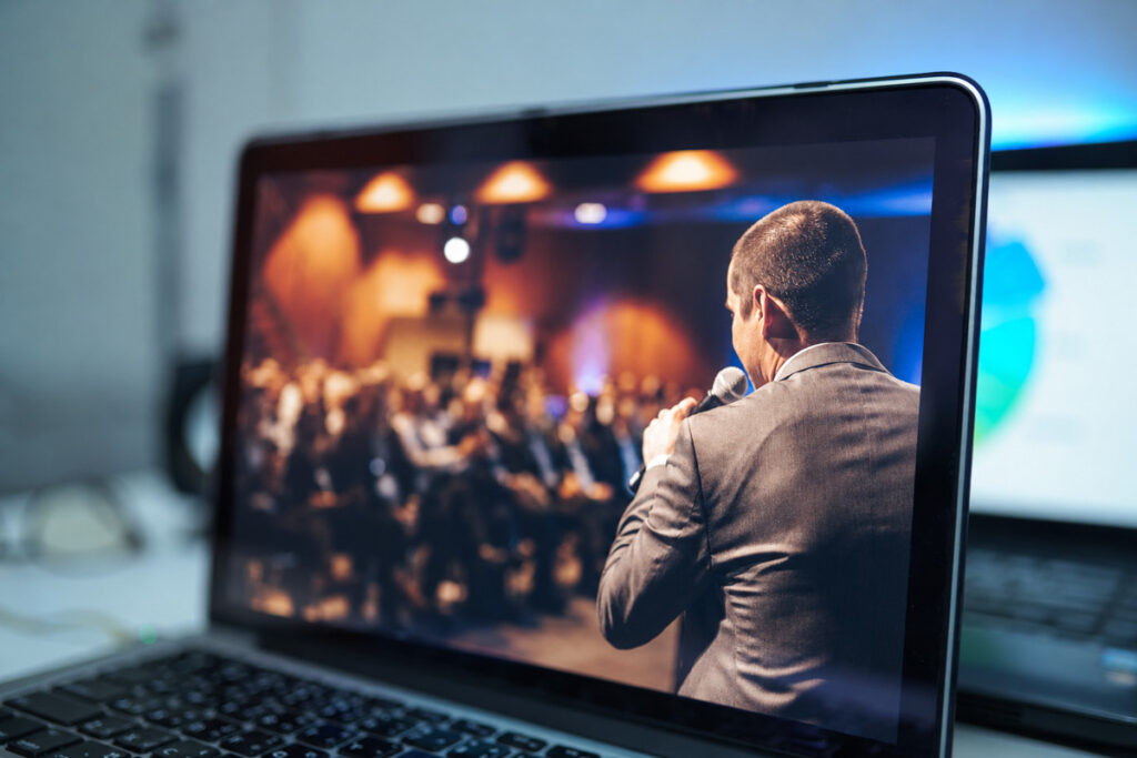 Corporate event photography of a keynote speaker presenting to an audience