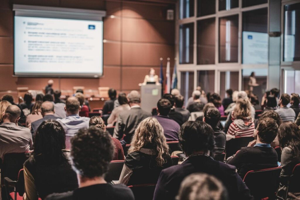 Corporate event photography showing a large audience attending a business conference