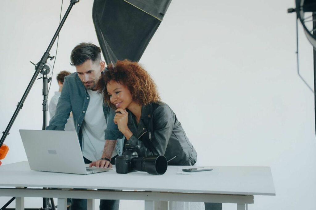 Photography team reviewing images on a laptop as part of an AI photo editing workflow