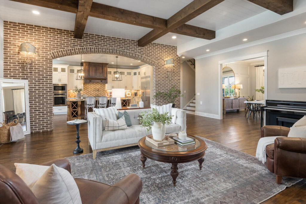 Lens distortion correction applied to a bright real estate living room with exposed beams and brick walls.
