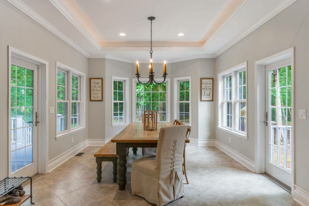 Lens distortion correction applied to a bright dining room with multiple windows and balanced proportions.