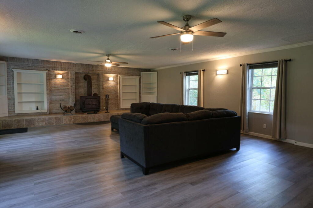Family room before lens distortion correction showing darker exposure and wide-angle perspective.