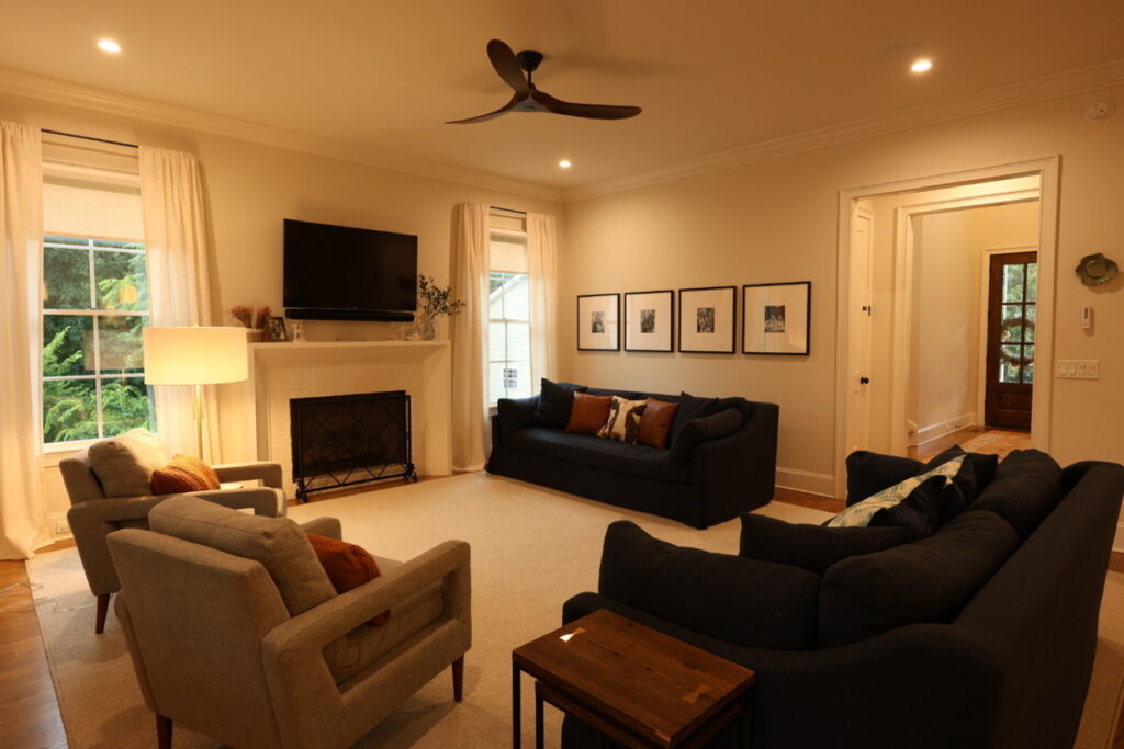 Living room before lens distortion correction with warm lighting and wide-angle perspective.