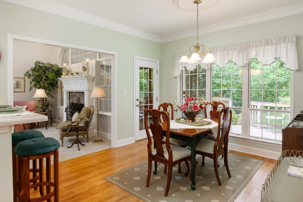 Lens distortion correction applied to a dining room with large windows, doorways, and balanced proportions.
