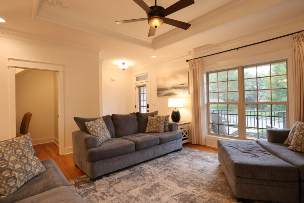 Living room before lens distortion correction showing warm tones and wide-angle perspective.