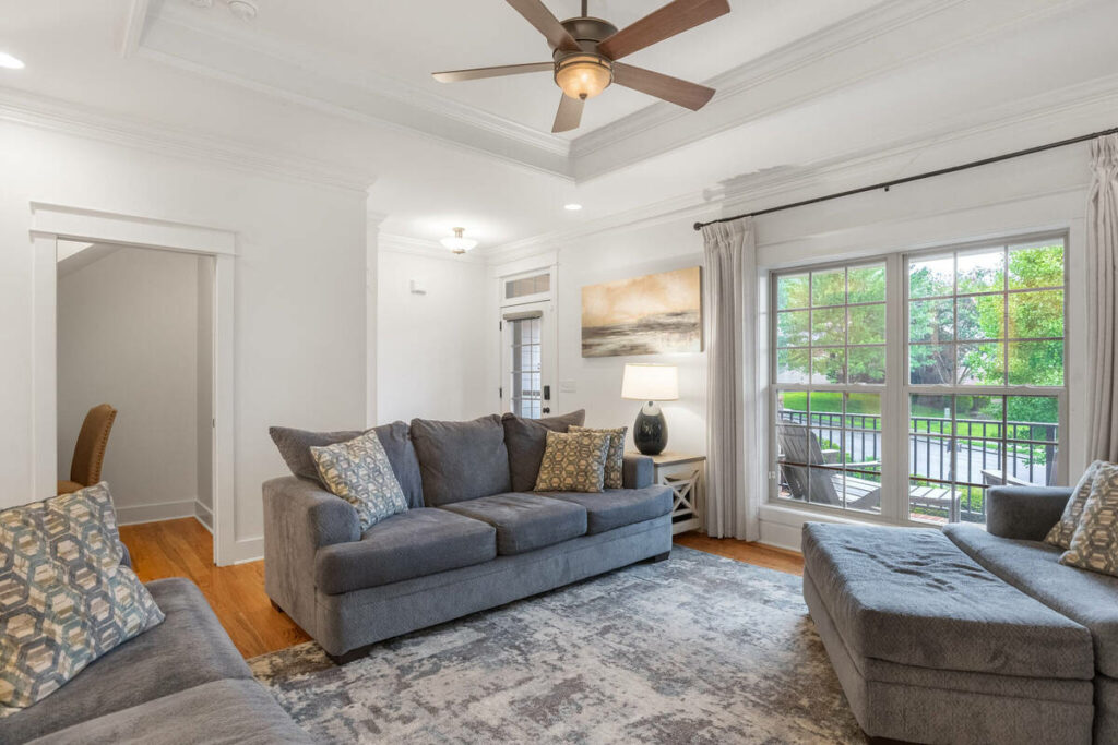 Lens distortion correction applied to a living room with large windows, straight walls, and balanced perspective.