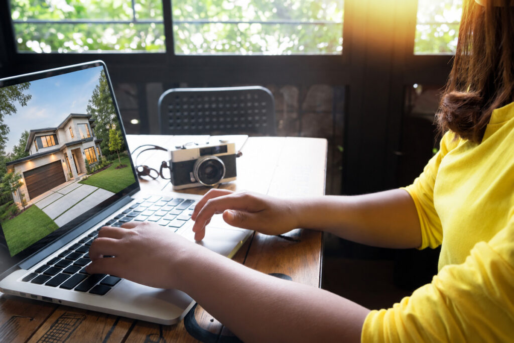 Photographer working on a laptop as part of a CRM for photographers workflow for managing real estate clients