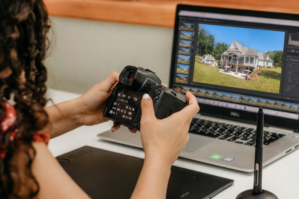 Photographer reviewing real estate images as part of how to scale a photography business