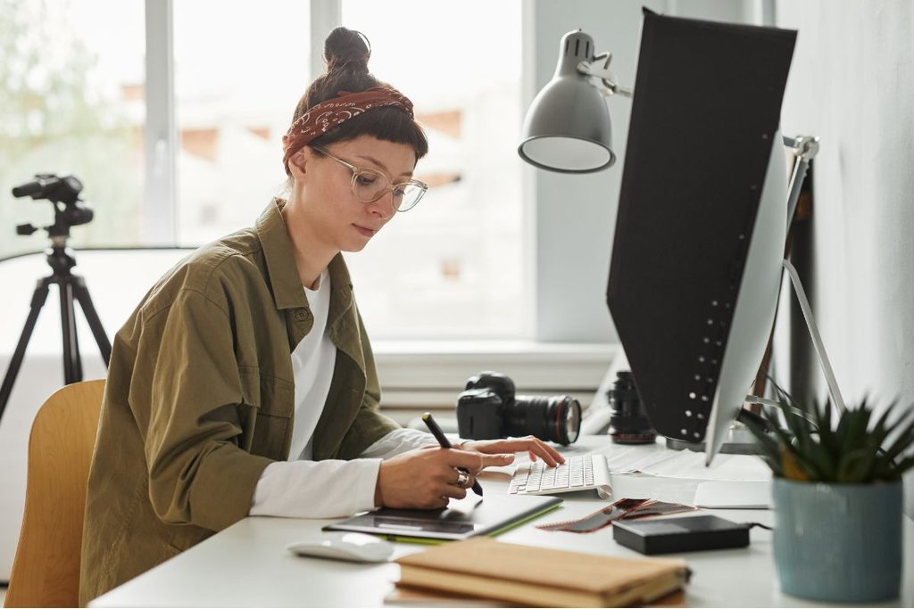 Photographer working at a desktop as part of a scalable photography business workflow