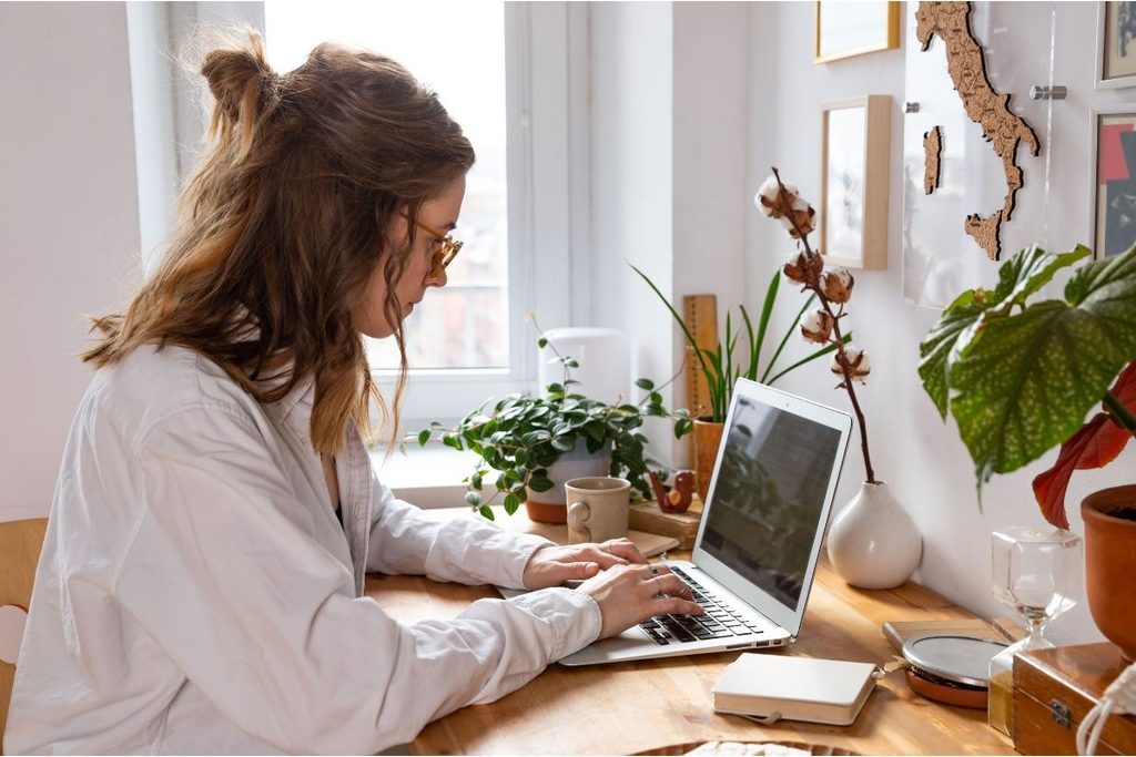 Growth Coordinator managing daily business tasks on a laptop.