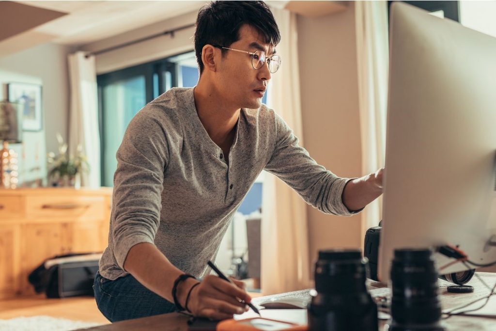 Photographer managing a photography business workflow at a desktop computer