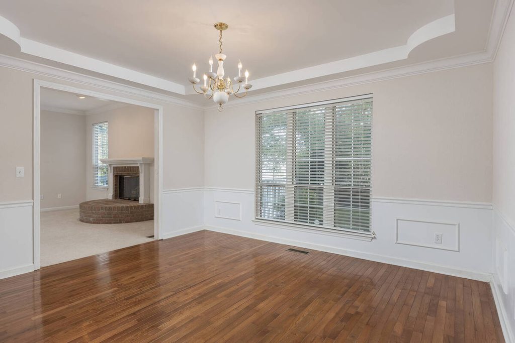 Empty formal dining room with hardwood floors before virtual staging