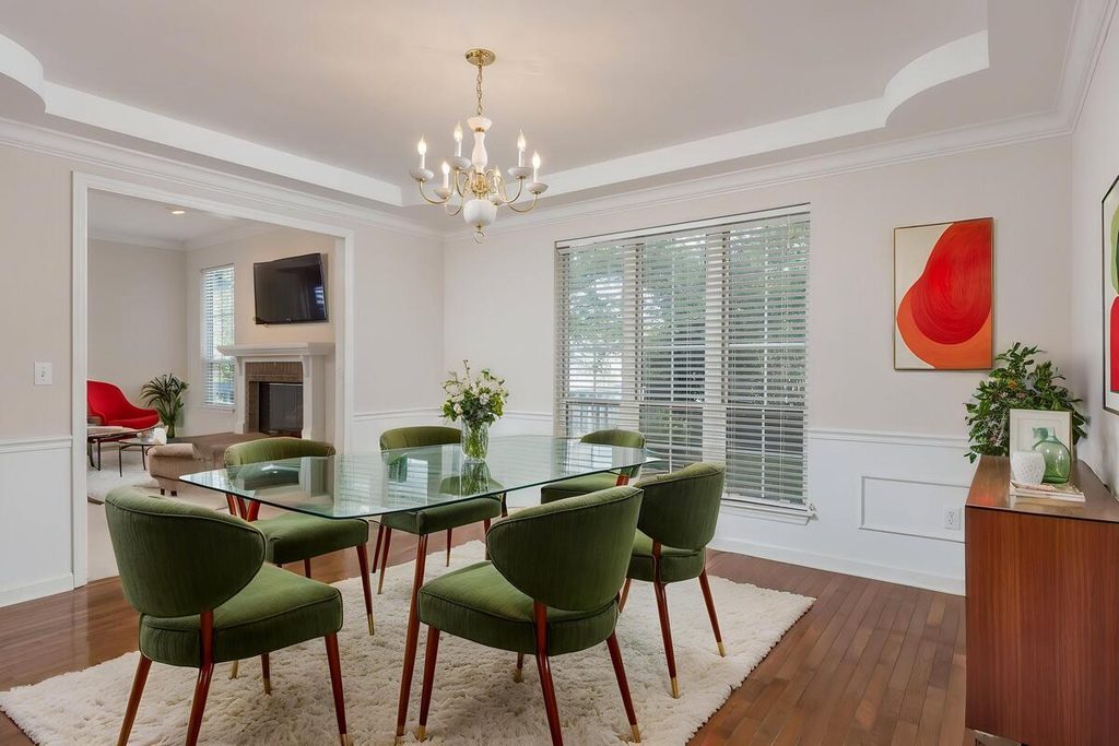 Virtual staging featuring a glass dining table and green velvet chairs
